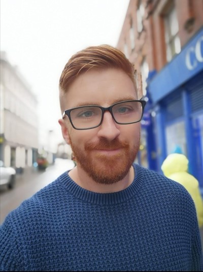 photo showing a man wearing glasses and a blue top.