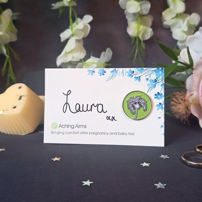 front view forget me not flower wedding favour with enamel dandelion pin badge and the name 